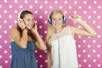 Two teenager girls listening to music with headphones