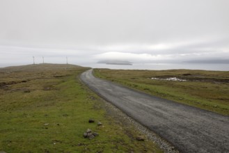 Street on the Faroe Islands in the south of Eysturoy with wind mills and nolsoy, Æduvik, Faroe