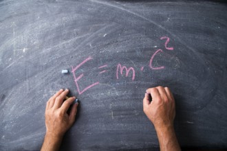 Representation of the energy formula designed with chalk on blackboard