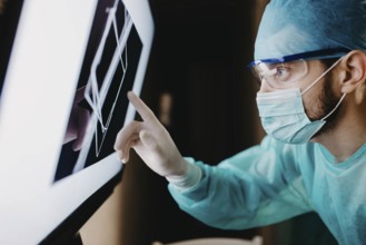 A surgeon analyzing data on a touch screen with concentration