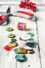 Thread, buttons, beads and scissors on the table light vintage