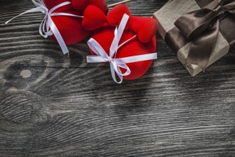 Present box red hearts on vintage wooden board holidays concept