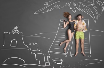 Love story concept of a romantic couple against chalk drawing background. Male lying on sun lounger