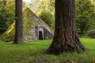 Pyramid-shaped, moss-covered mausoleum, surrounded by tall trees, mystical atmosphere,