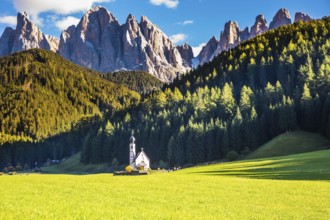 Dolomites, Tirol. Sunny autumn day. The famous symbol of the valley Val di Funes - church of Santa