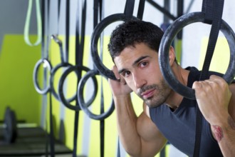 Crossfit dip ring man relaxed after workout at gym dipping exercise