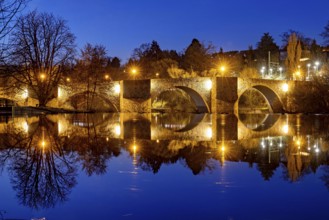 Night scene with illuminated stone bridge and reflecting water, The historic Bartenwetz stone
