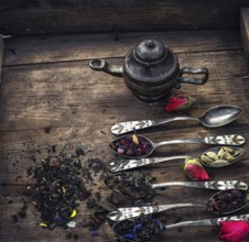 Varieties of dry tea infuser scattered on wooden table