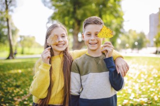 Friendship between siblings. Siblings together outside with bright coloured background. Kids autumn