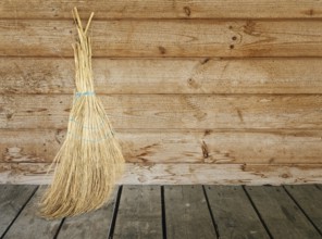 Single broom against the old wooden wall