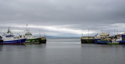 Greencastle, Ireland, 9 July, 2022: colorful fishing boats and trawlers in the sheltered port and