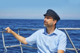 Beard sailor man sailing sea ocean in a boat with captain cap looking horizon