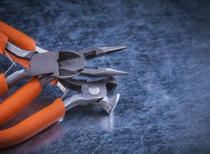 Composition of insulated electric pliers nippers on scratched metallic background