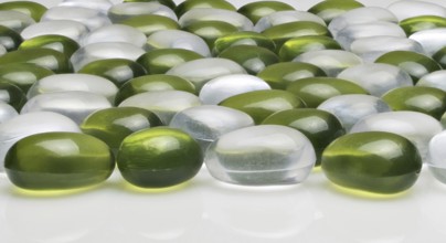 Artificial round stones of green and white color. imitation pebbles