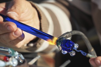 Delicate work of the glass blower. On a photo hands of the master are visible. The Artist-glass