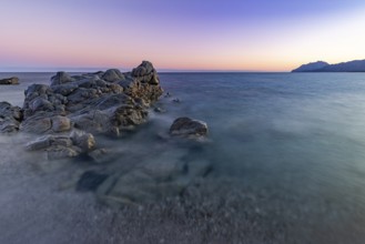 Rocks in the sea on the beach of Torre di Bari at sunset, long exposure, Torre di Bari, Bari Sardo,
