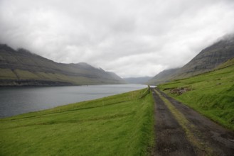 Gravel street on the Faroe Islands with the village Hvannasund in the background, Hvannasund, Faroe