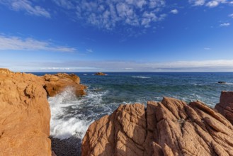 Coastal landscape with red rocks and surf in blue sky and sunshine, Spiaggia di Cala E'Luas,