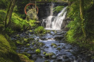 Stream leading to red waterwheel and waterfall in Glenariff Forest Park, County Antrim, Northern