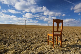 Old wooden chair on the empty field after harvest