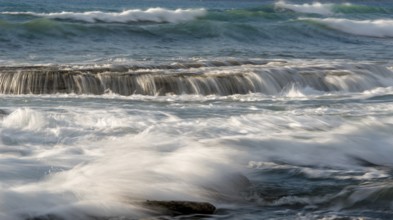 Rocky seashore with wavy ocean and waves crashing on the rocks at Akrotiri coast area in Limassol,