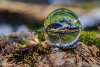 Close-up of a crystal ball reflecting a river landscape, Perlbachtal, NIederbayern