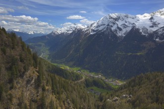 Beautiful top view of high snow-covered mountains and valley with road and village in Switzerland