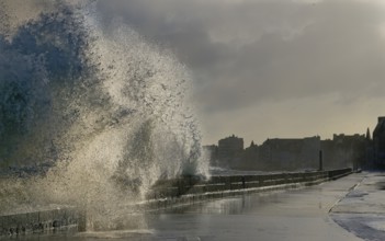 Massive ocean splash against a sea wall on a stormy, overcast day by the coast, Saint-Malo,