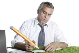 Businessman senior sign bank check funny humor gesture big pencil on green grass