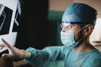 Medical professional scrutinizing x-ray with measured focus