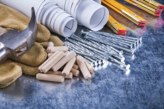 Construction drawings hammer safety gloves wooden meter metal nails and dowels on scratched