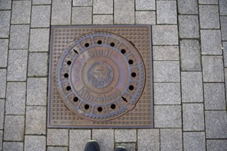 Manhole cover with motif on John the Baptist, Bible, town coat of arms, coat of arms, Künzelsau,