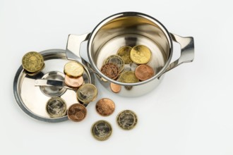 A cooking pot with a few euro coins, a symbolic photo of sovereign debt and the financial crisis in