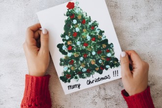 DIY Making greeting card Handmade crafts on holiday for children. Paint with fingers Merry