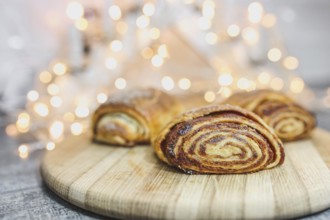 Cinnamon pastries on a wooden board with soft glowing lights