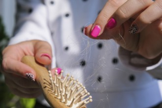 Hair loss on the comb, massage wooden brush with a clump of hair, problem of growth, hair care