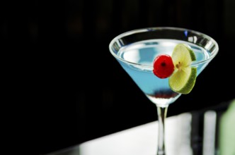 Blue curacao cocktail with cherry and lime