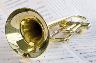 Closeup of trumpet lying on sheet music