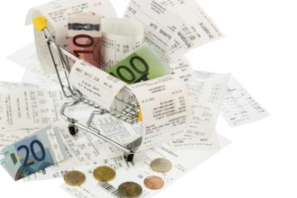 Shopping trolleys, banknotes and receipts, symbolising purchasing power, consumption and inflation
