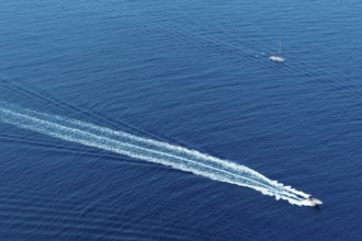 Boat surf foam aerial from prop wash in blue Majorca mediterranean sea