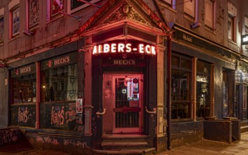 The façade of a traditional Hamburg pub with glowing red neon lights at night, Hans-Albers-Eck, St.