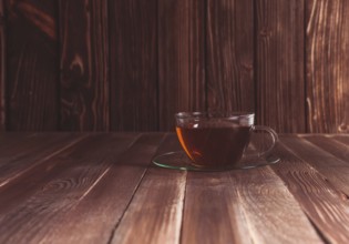 Glass cup of tea on a wooden table