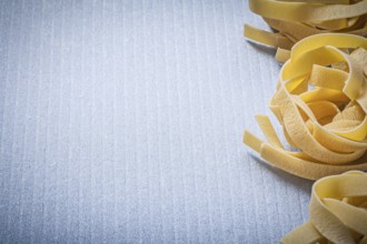 Copy space of rolled pasta fettuccine on blue background food and drink concept