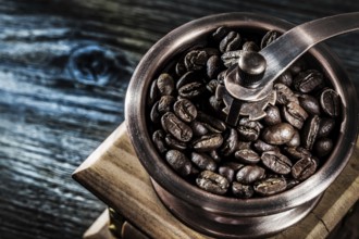 Coffee grinder beans on wooden board