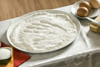 Imprint of a woman's hand in a bowl with the flour