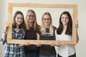 Group of girls smiling through a picture frame - portrait