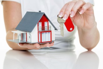 A real estate agent for properties with a house and a key Successful letting and house sales by