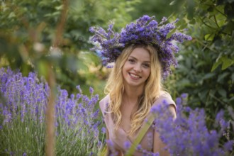 Blonde woman in wreath near lavender bushes at the garden
