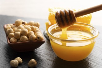 Slate tray with honey hazelnuts and honeycomb on kitchen table, food photography, food photography