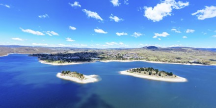 The view towards the town of Jindabyne over Lion and Cub Islands in Lake Jindabyne on a warm sunny